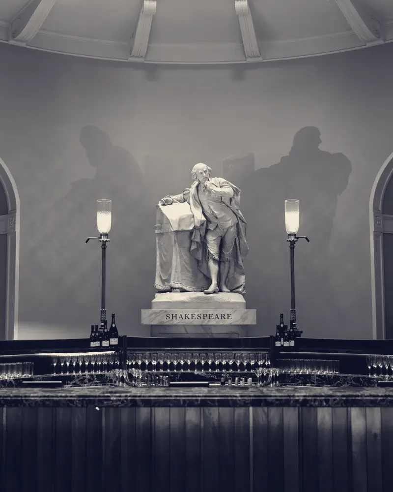 A statue lit by two lamps above the bar at Theatre Royal Drury Lane