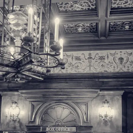 Brass light fittings and a chandelier above a box office